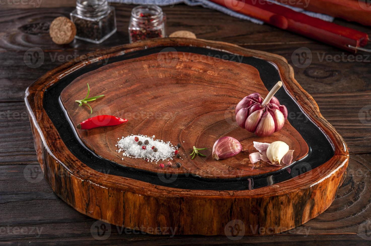 tabla de cortar de resina de madera con especias y tenedor y cuchillo de barbacoa en la mesa de madera. foto