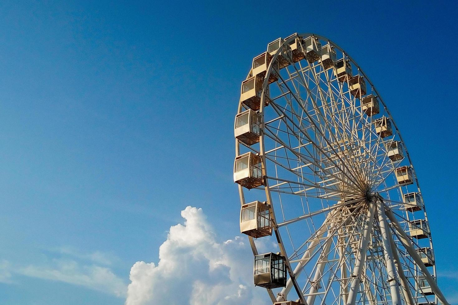 observation wheel against beautiful blue sky with clouds photo