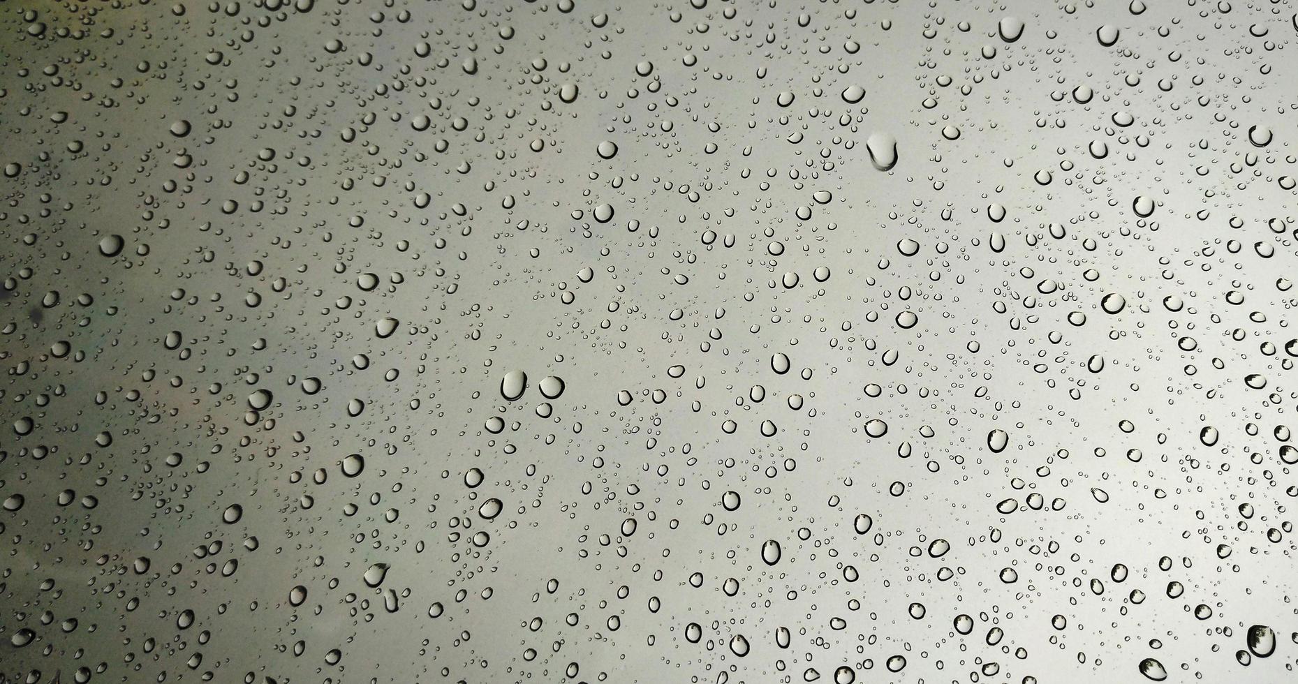Gotas de lluvia sobre fondo de ventana de cristal rojo foto