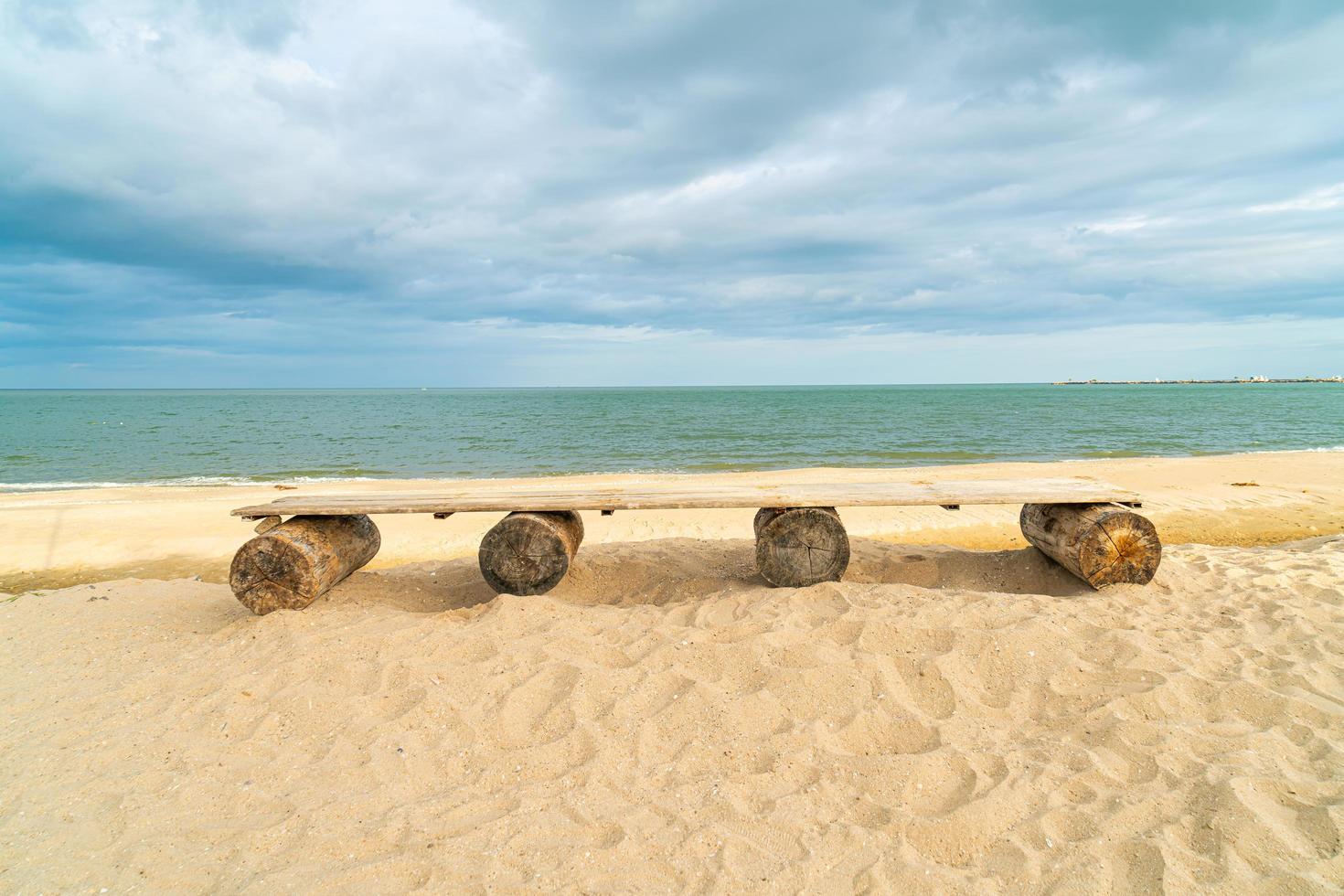 wood bench on beach with sea beach background photo