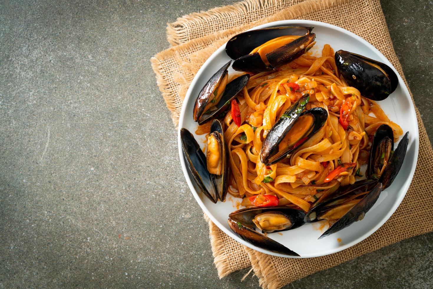 pasta de espagueti con mejillones o almejas y salsa de tomate foto