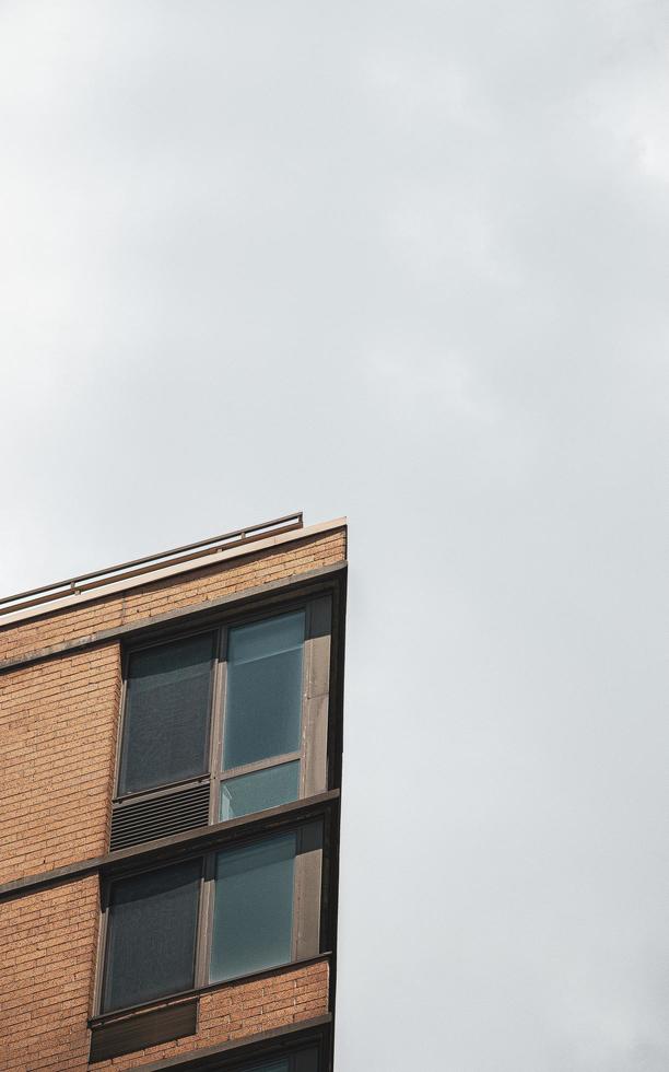 Edificio de hormigón marrón bajo un cielo blanco durante el día foto