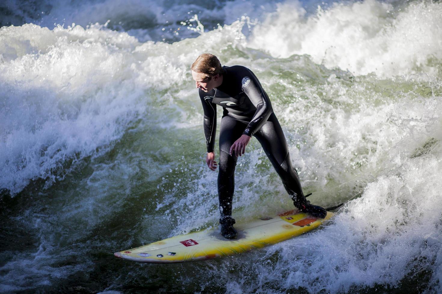 MUNICH, GERMANY, OCTOBER 23 - Unidentified surfer in the Eisbach river in English Garden in Munich, Germany at October 23, 2011. The first surfers discovered the Eisbach in the 1970's. photo