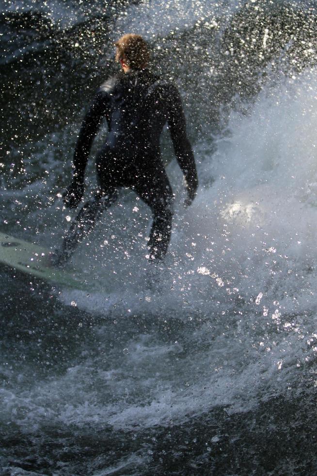 MUNICH, GERMANY, OCTOBER 23 - Unidentified surfer in the Eisbach river in English Garden in Munich, Germany at October 23, 2011. The first surfers discovered the Eisbach in the 1970's. photo