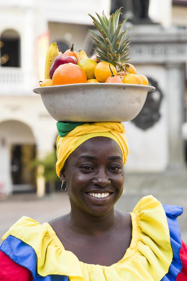 CARTAGENA, COLOMBIA, SEPTEMBER 16, 2019 - Unidentified palenquera, fruit seller lady on the street of Cartagena. These Afro-Colombian women come from village San Basilio de Palenque, outside the city. photo
