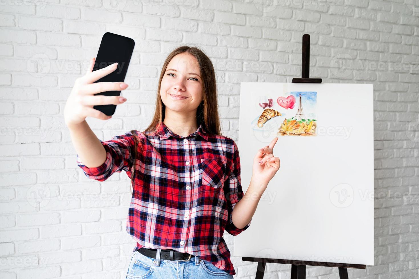 Artista joven tomando un selfie con su foto