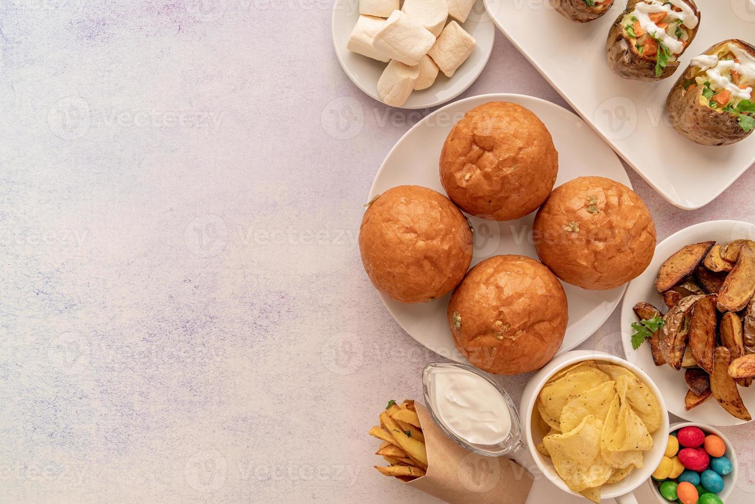 Hamburguesas de comida no saludable, papas fritas y dulces, vista superior plana con espacio de copia foto