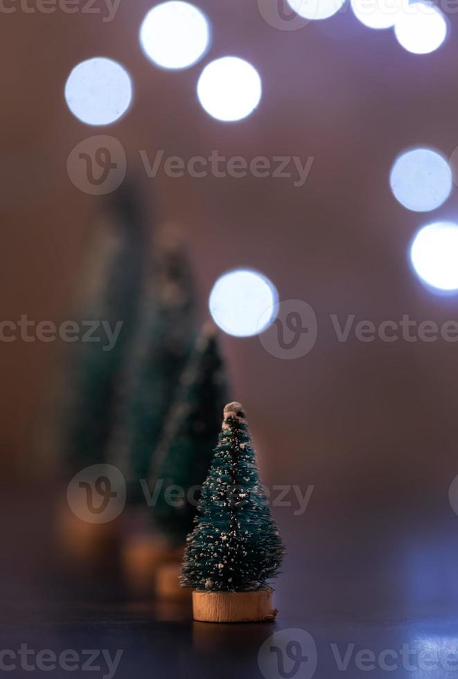 Christmas tree decorations standing in the line with fairy lights background with copy space photo