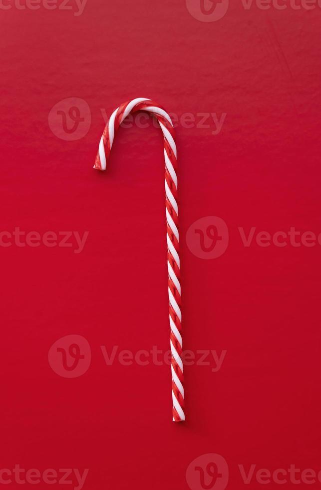 White and red candy cane isolated on red background photo