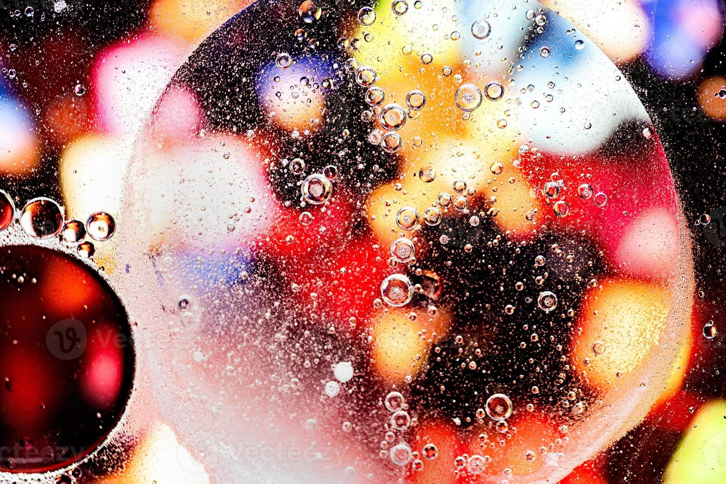Red and yellow abstract pattern made with oil bubbles on water photo