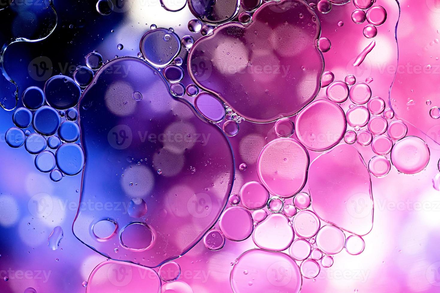 Blue and purple abstract pattern made with oil bubbles on water photo