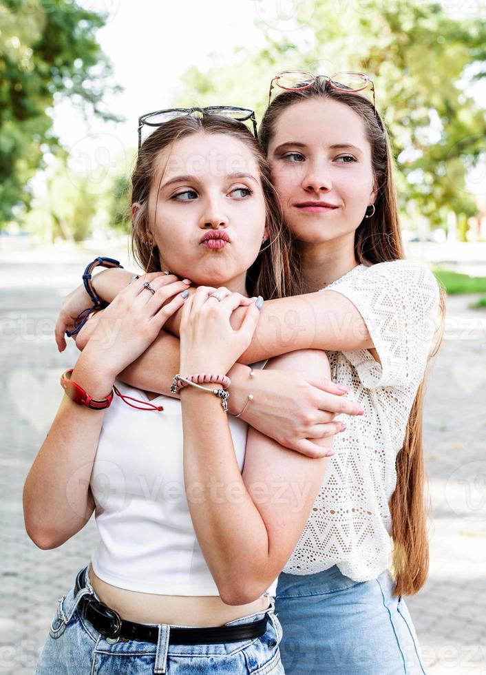 Cerrar dos lindos mejores amigos abrazándose al aire libre foto