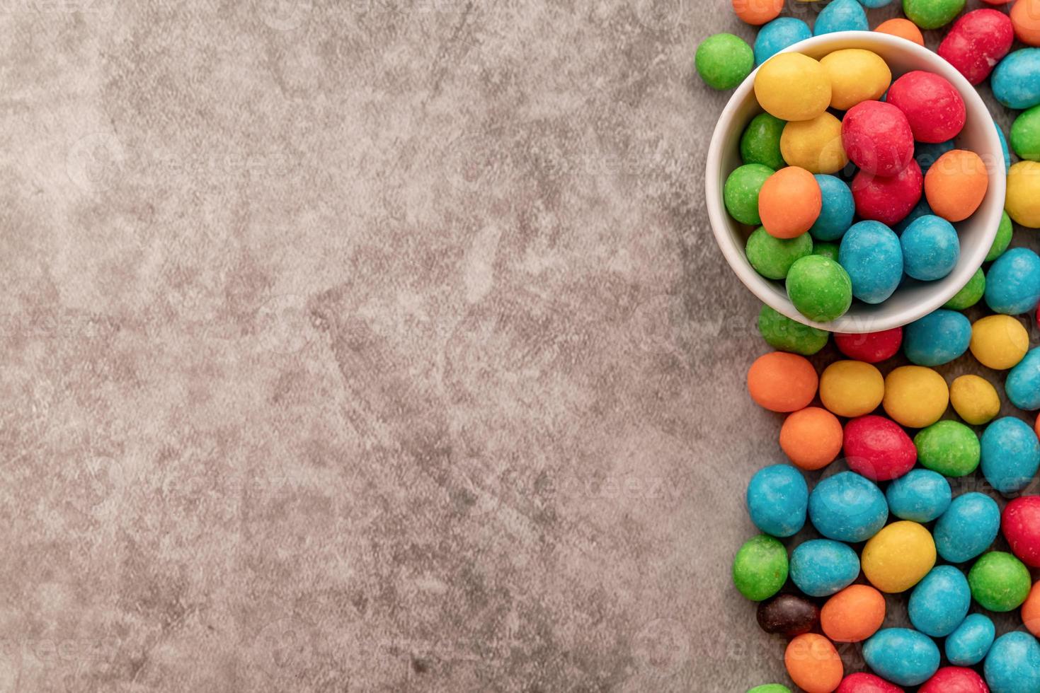 Vista superior de caramelos de colores sobre fondo oscuro foto