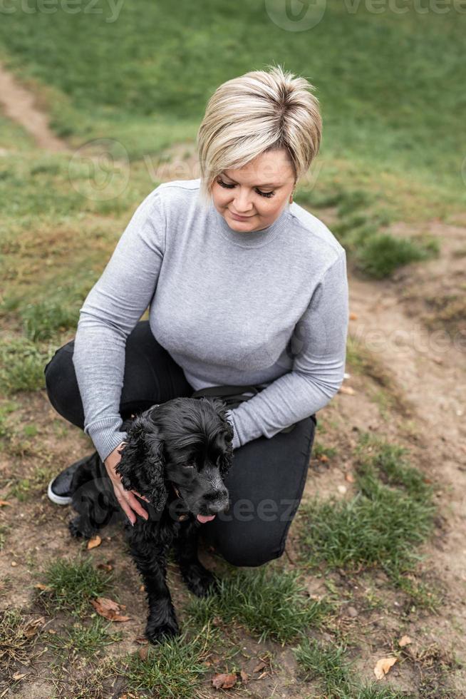 Black Cocker Spaniel with his owner in the park photo