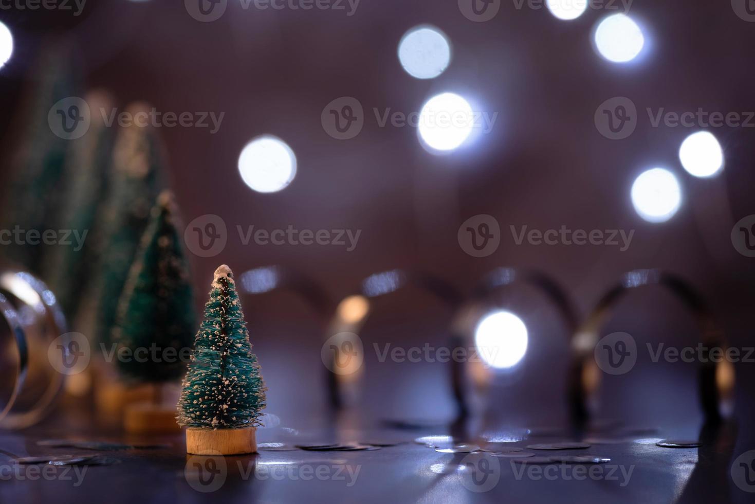 Christmas tree decorations standing in the line with fairy lights background with copy space photo