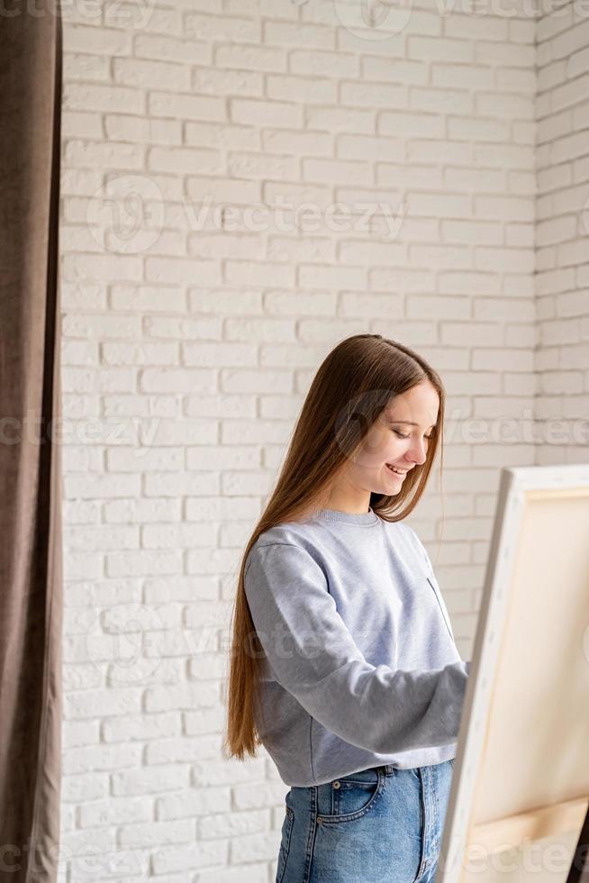 Female artist painting on the canvas in the studio photo