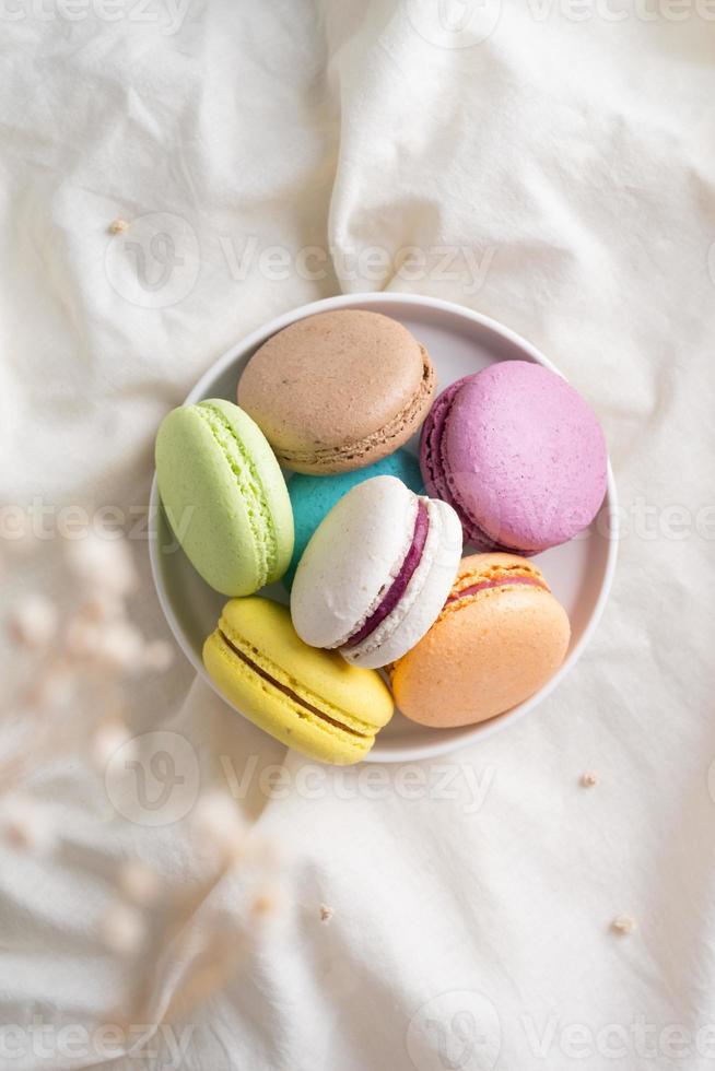 colorful macaroons on the plate on the bed photo
