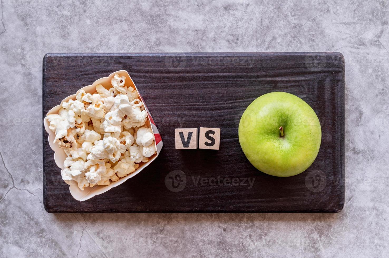 palomitas de maíz versus vista superior de manzana sobre fondo oscuro foto