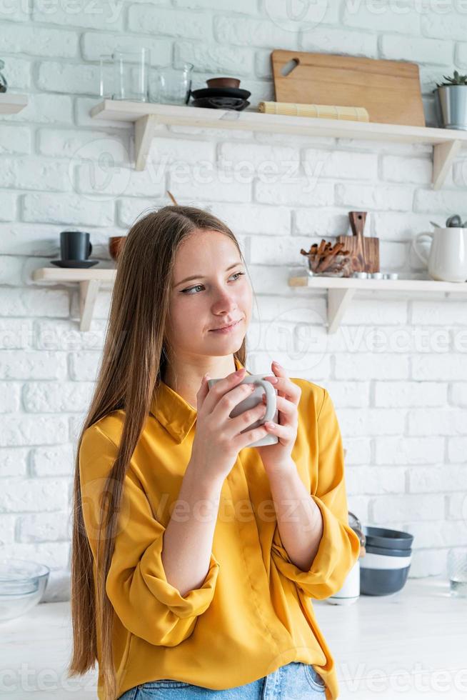 Attractive woman drinking tea in her kitchen photo