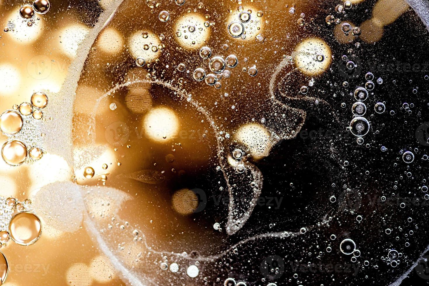 Black and gold abstract pattern made with oil bubbles on water photo