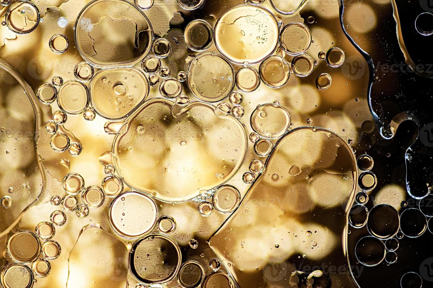 patrón abstracto negro y dorado hecho con burbujas de aceite en el agua foto