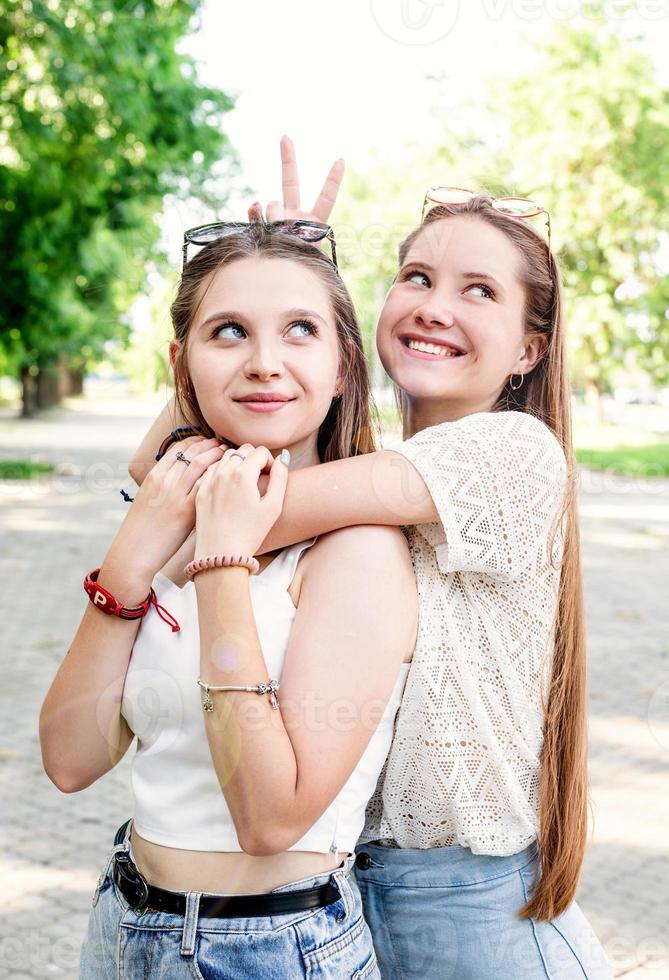 Happy girlfriends hugging together outdoors photo