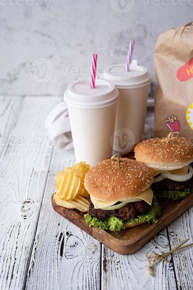 Set of homemade burgers, chips and drink photo