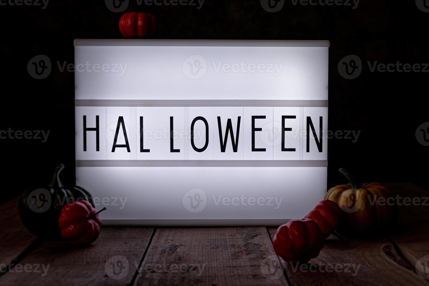 Halloween light box in the dark room with pumpkins on wooden floor photo