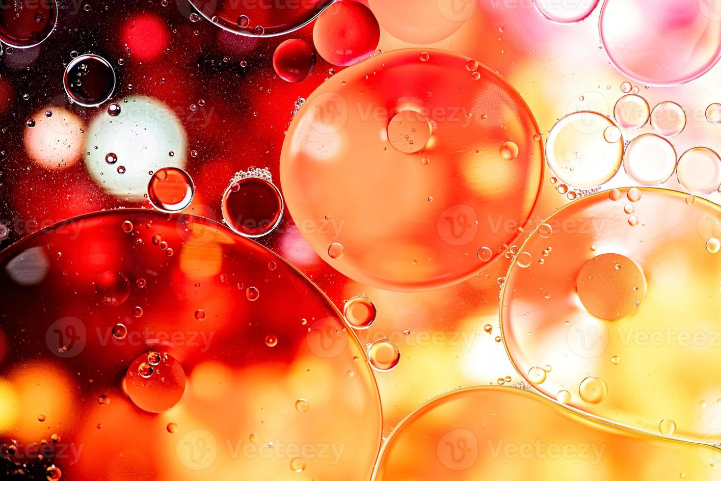 Yellow and orange abstract pattern made with oil bubbles and lights on water photo