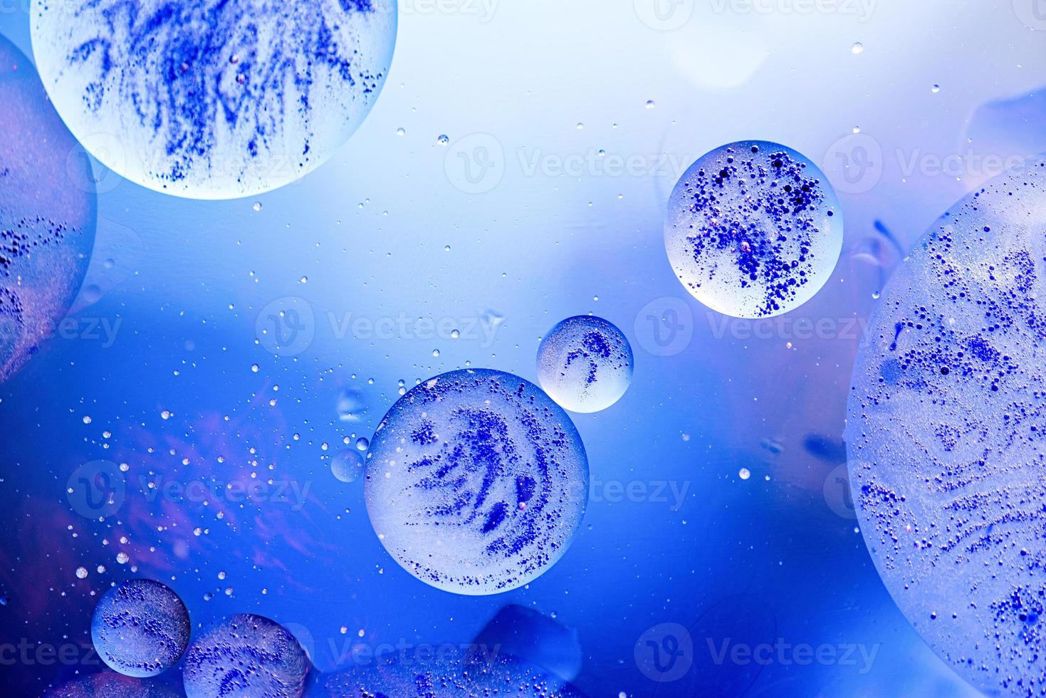 Bright blue bubbles with black ink on water surface in abstract background photo