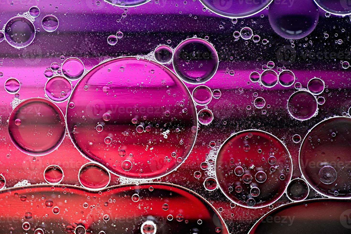 Patrón abstracto rosa y morado hecho con burbujas de aceite en el agua que sube en movimiento foto