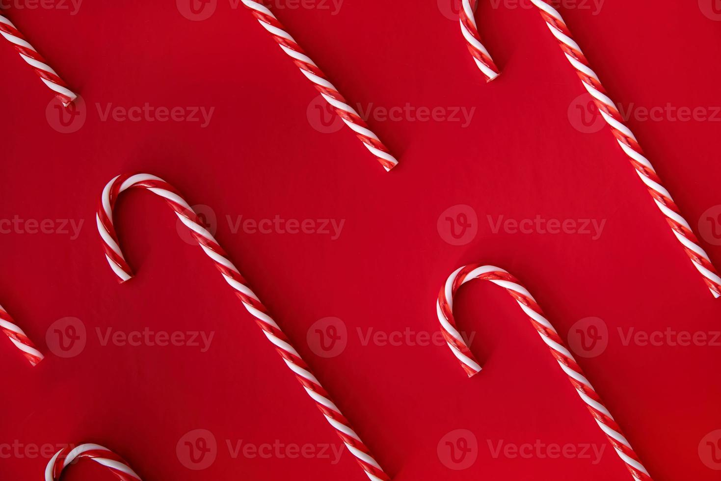 candy canes pattern top view on bright red background photo