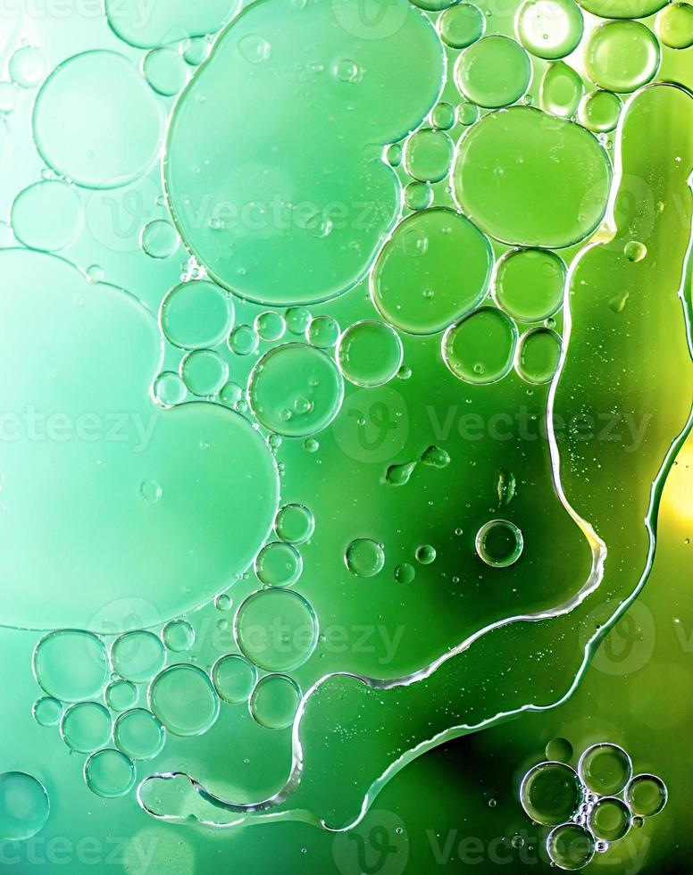 Bright green colorful bubbles on water surface in abstract background photo