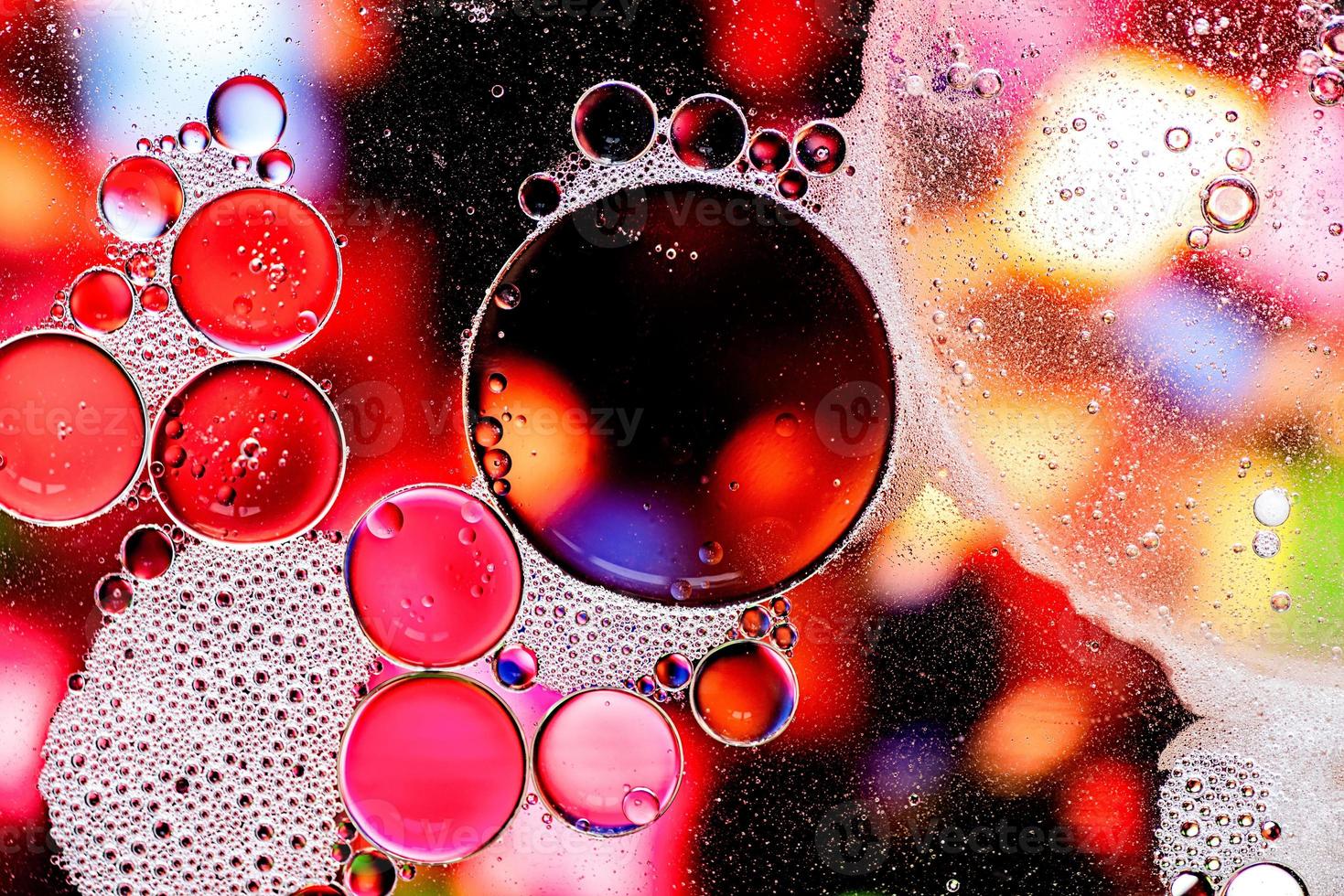 Pink and purple abstract pattern made with oil bubbles on water photo