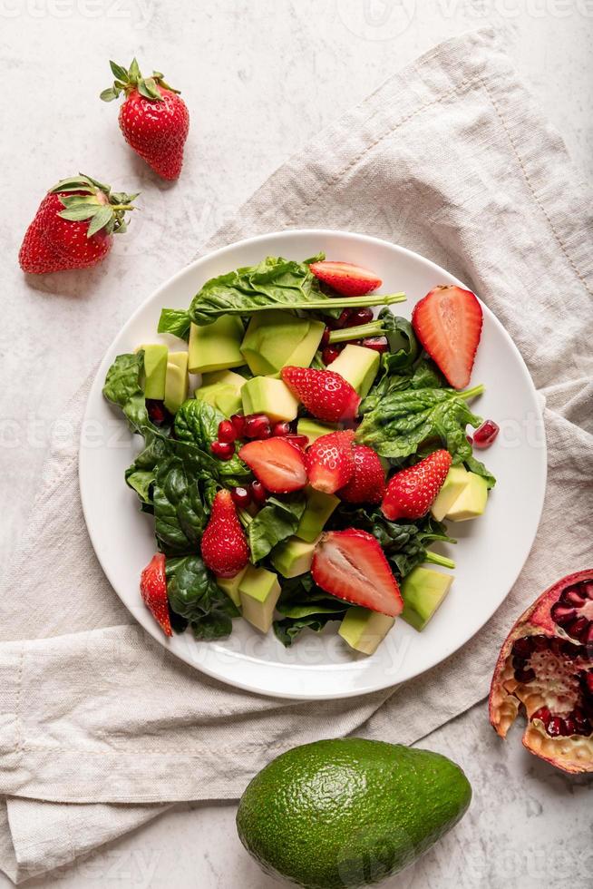 Ensalada con espinacas, aguacate y fresas sobre fondo blanco vista superior laicos plana foto