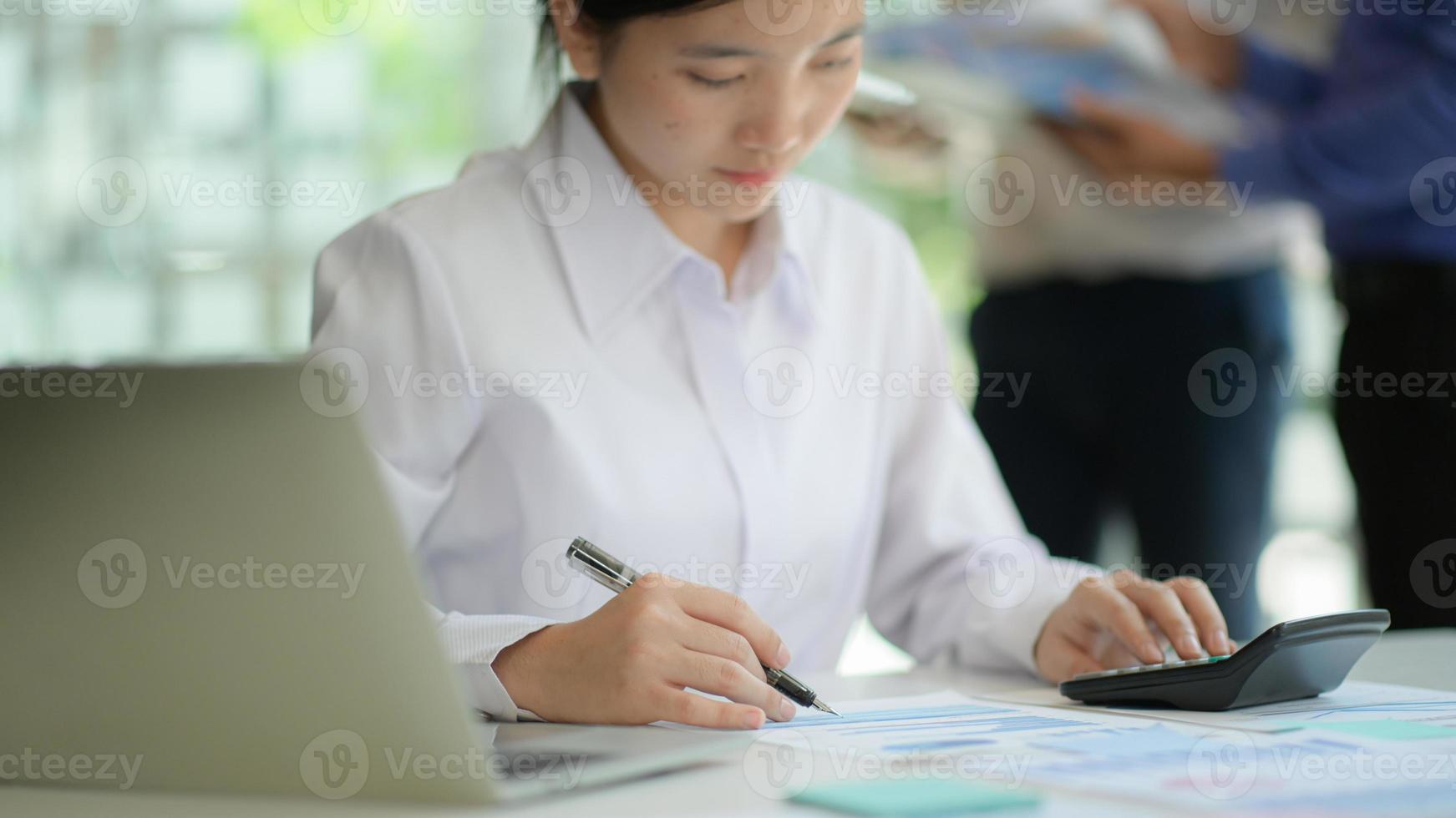 Business women work on projects with charts and graphs and laptop in the office. photo