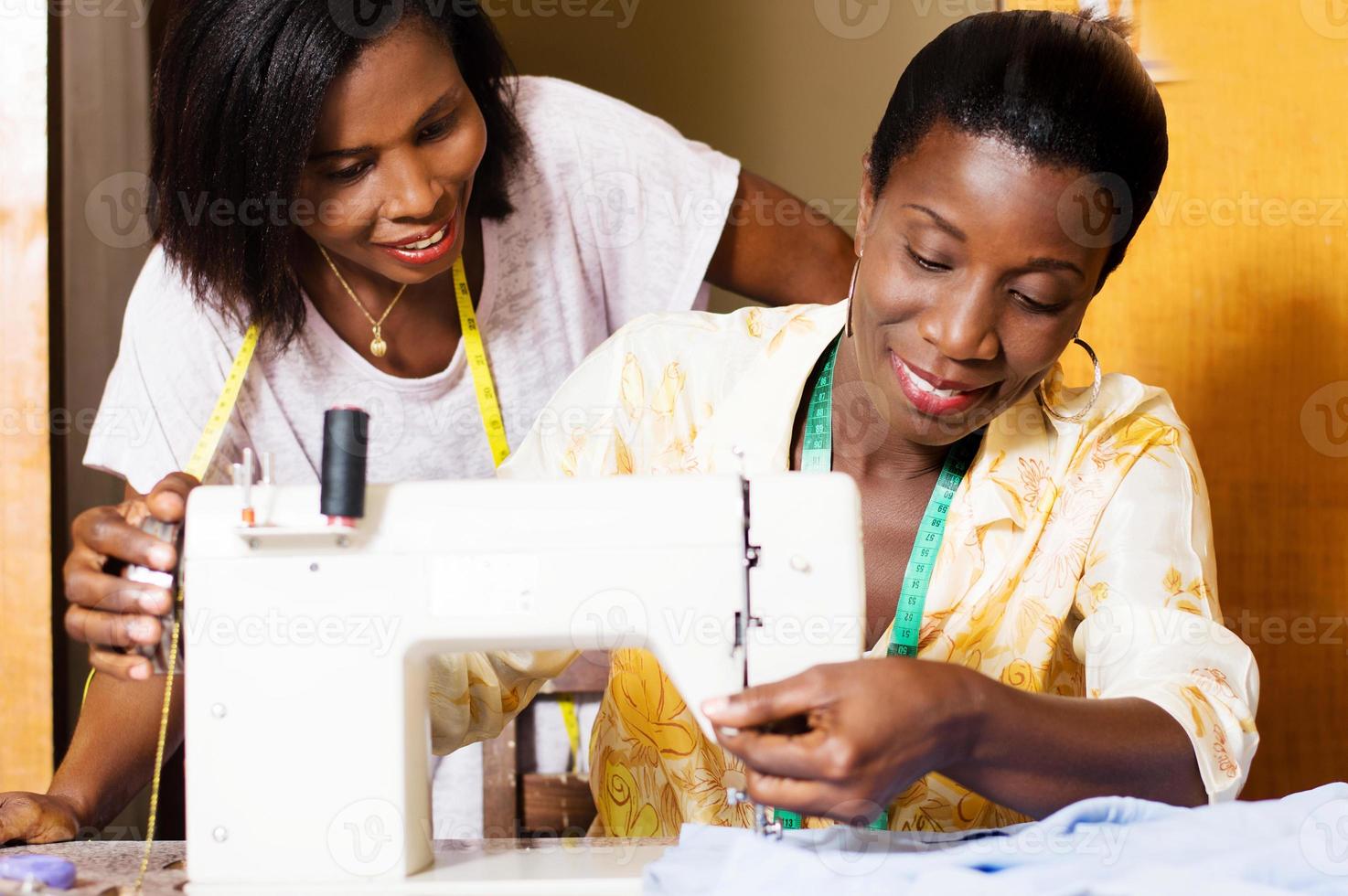 happy seamstresses behind a sewing machine photo