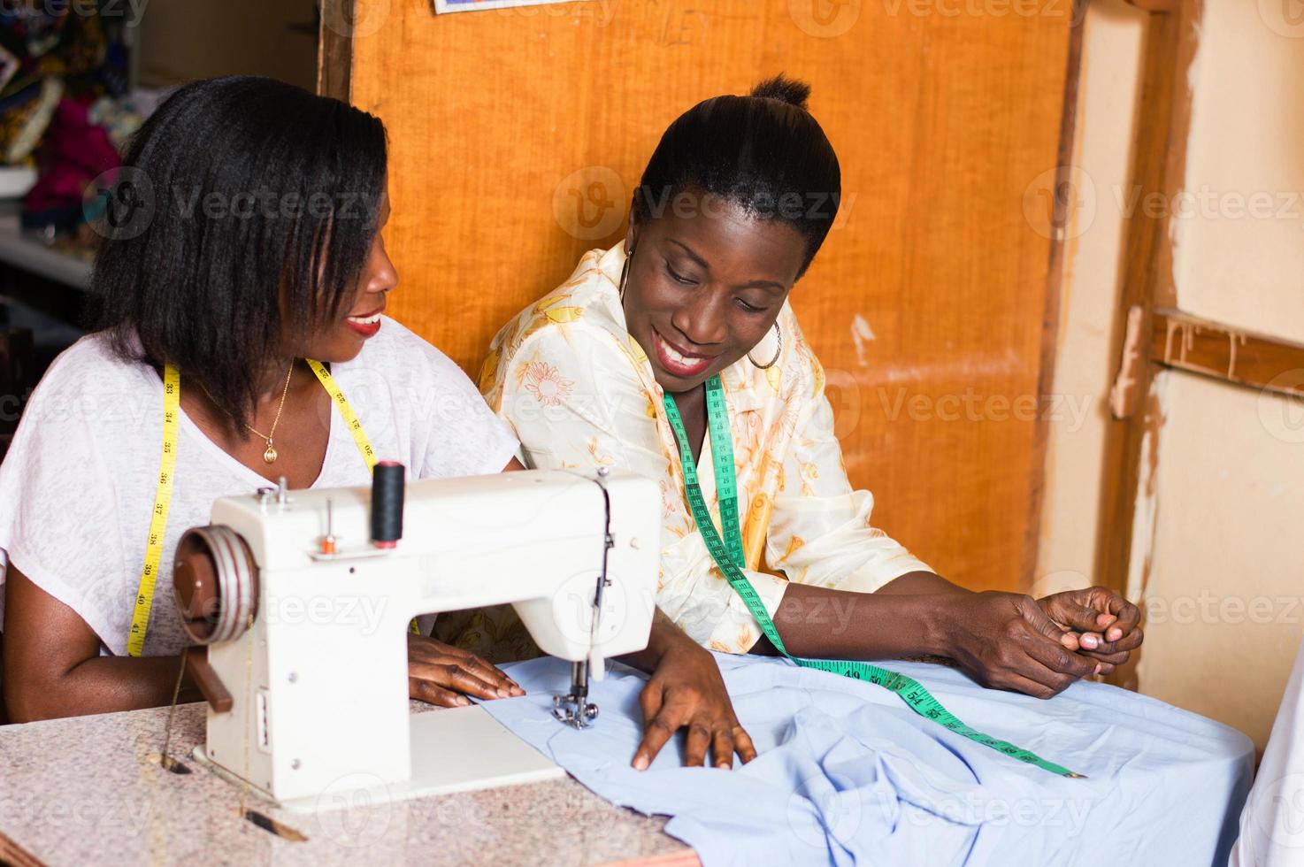 the student sews with her teacher in the workshop. photo