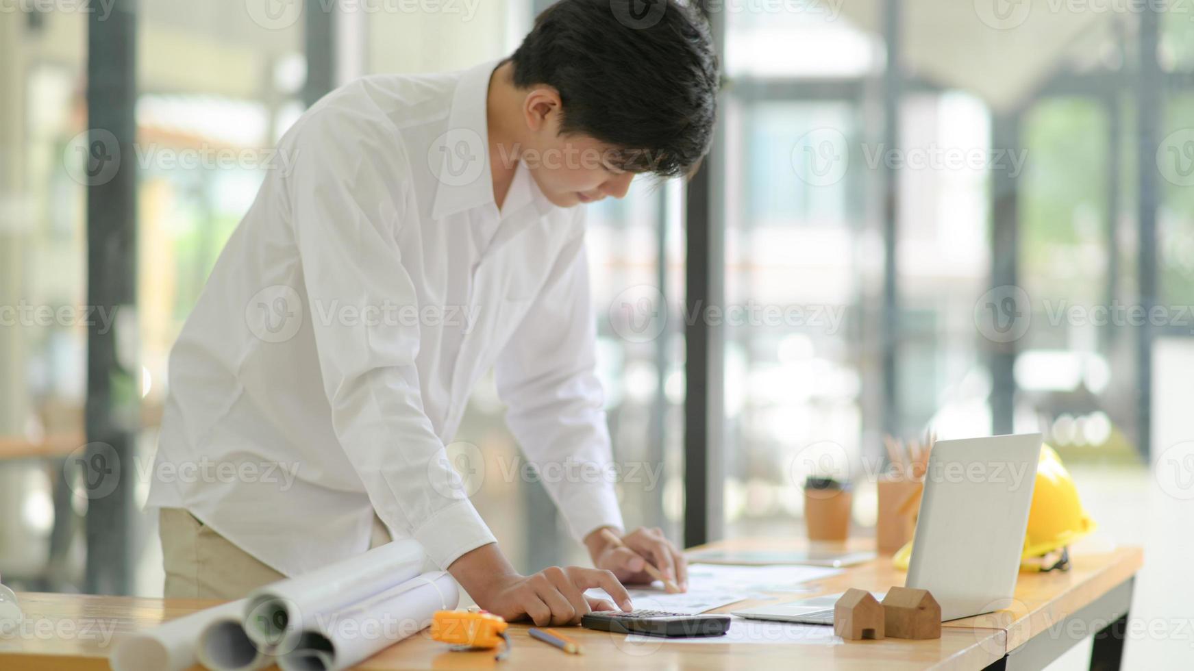 Architects use calculator to design and plan building construction for clients. photo