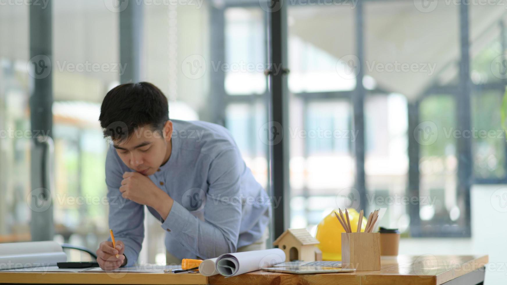 Engineering is checking the floor plan in the office with equipment placed on the work desk. photo