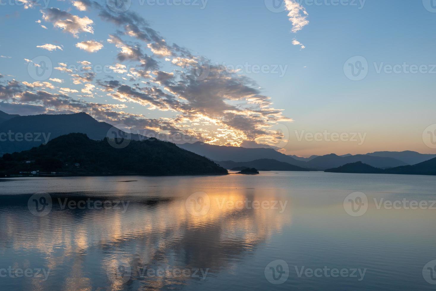 The evening lake reflected the sunset glow and mountains photo