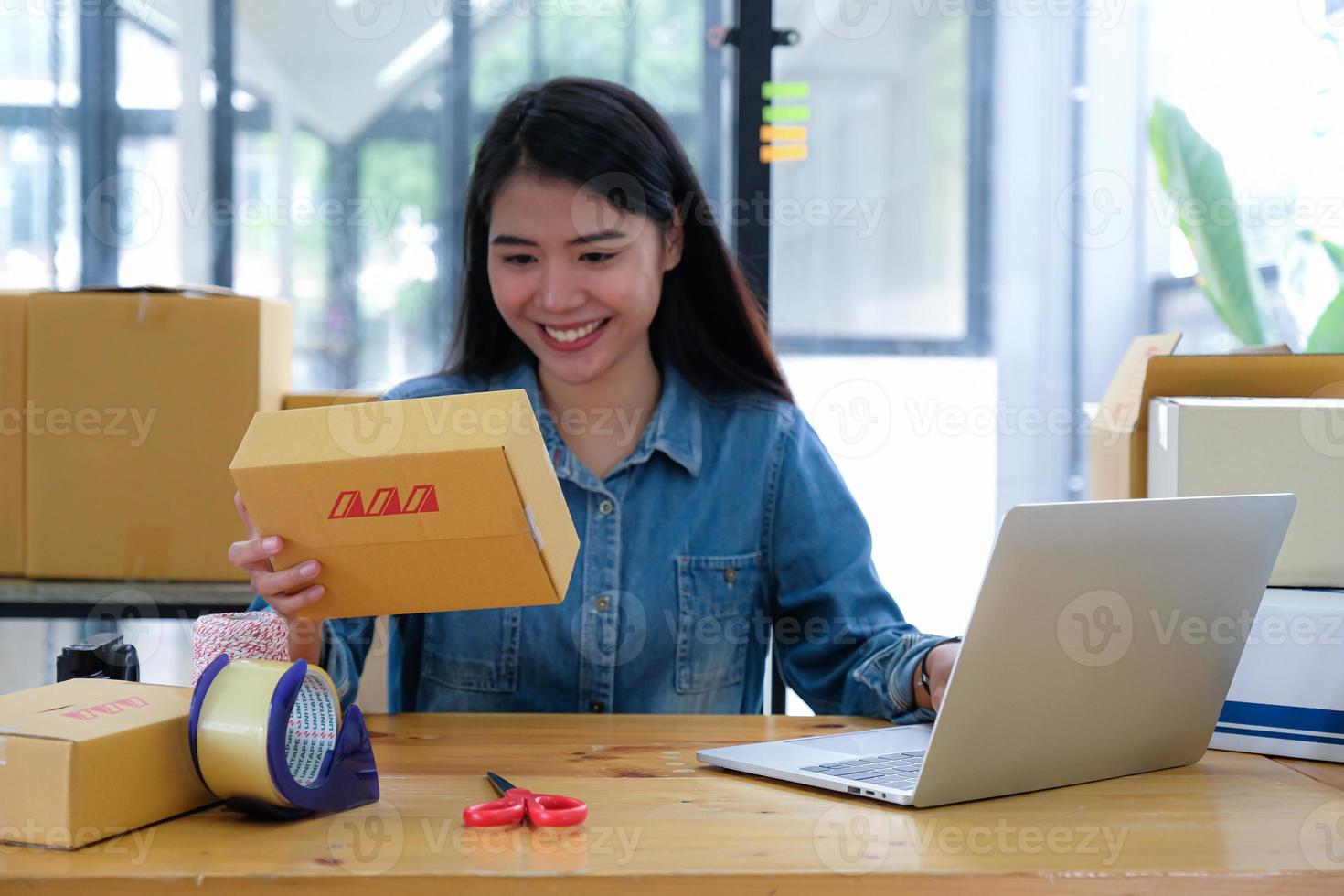 The parcel delivery staff is keying the product number with a laptop. photo