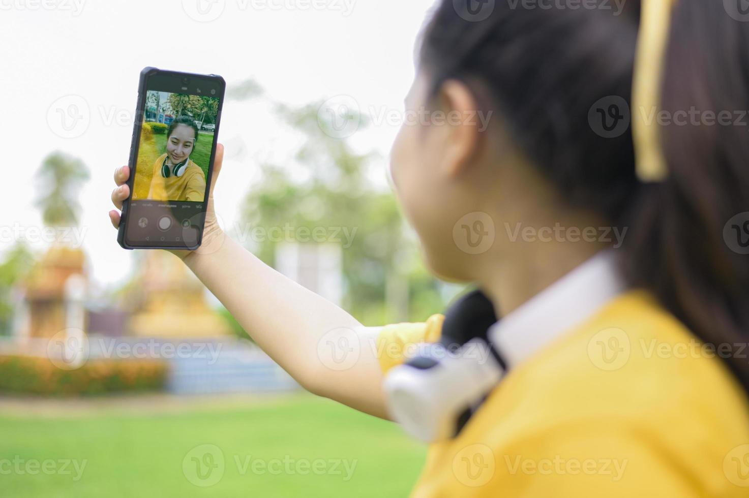 una mujer joven que toma un selfie con un teléfono inteligente. foto