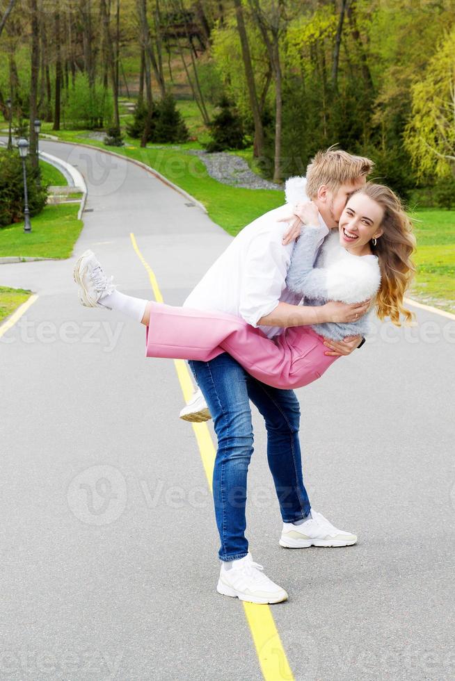 Beautiful couple fooling around on the street on green forest background photo