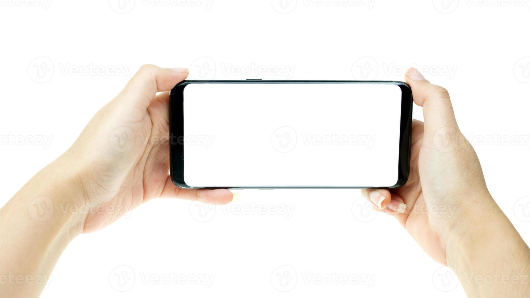 Woman hand holding black mobile phone with white screen at the background photo