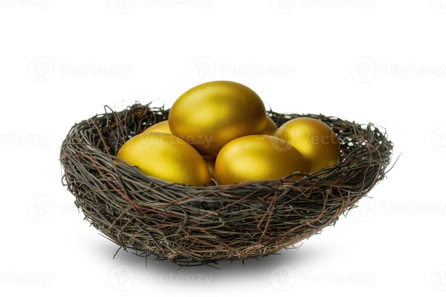 Huevos de oro en nido decorativo aislado en fondo blanco. foto