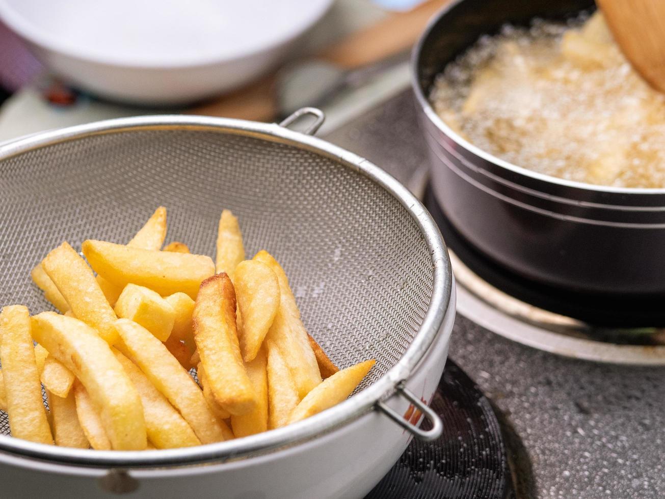 https://static.vecteezy.com/system/resources/previews/003/735/775/non_2x/frying-french-fries-in-the-fryer-in-hot-oil-on-the-electric-stove-in-the-kitchen-and-french-fries-in-a-basket-to-drain-the-oil-making-homemade-french-fries-selective-focus-free-photo.jpg