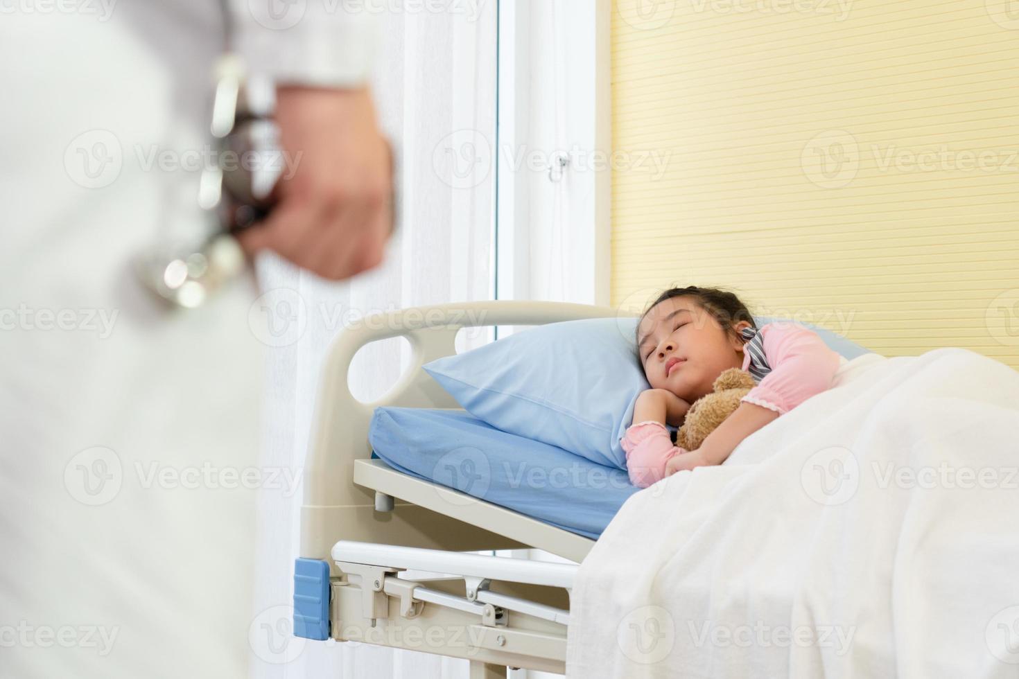 asian doctor visit young girl and mother who is sick and admitted at pediatric ward in hospital. healthcare and medical concept photo