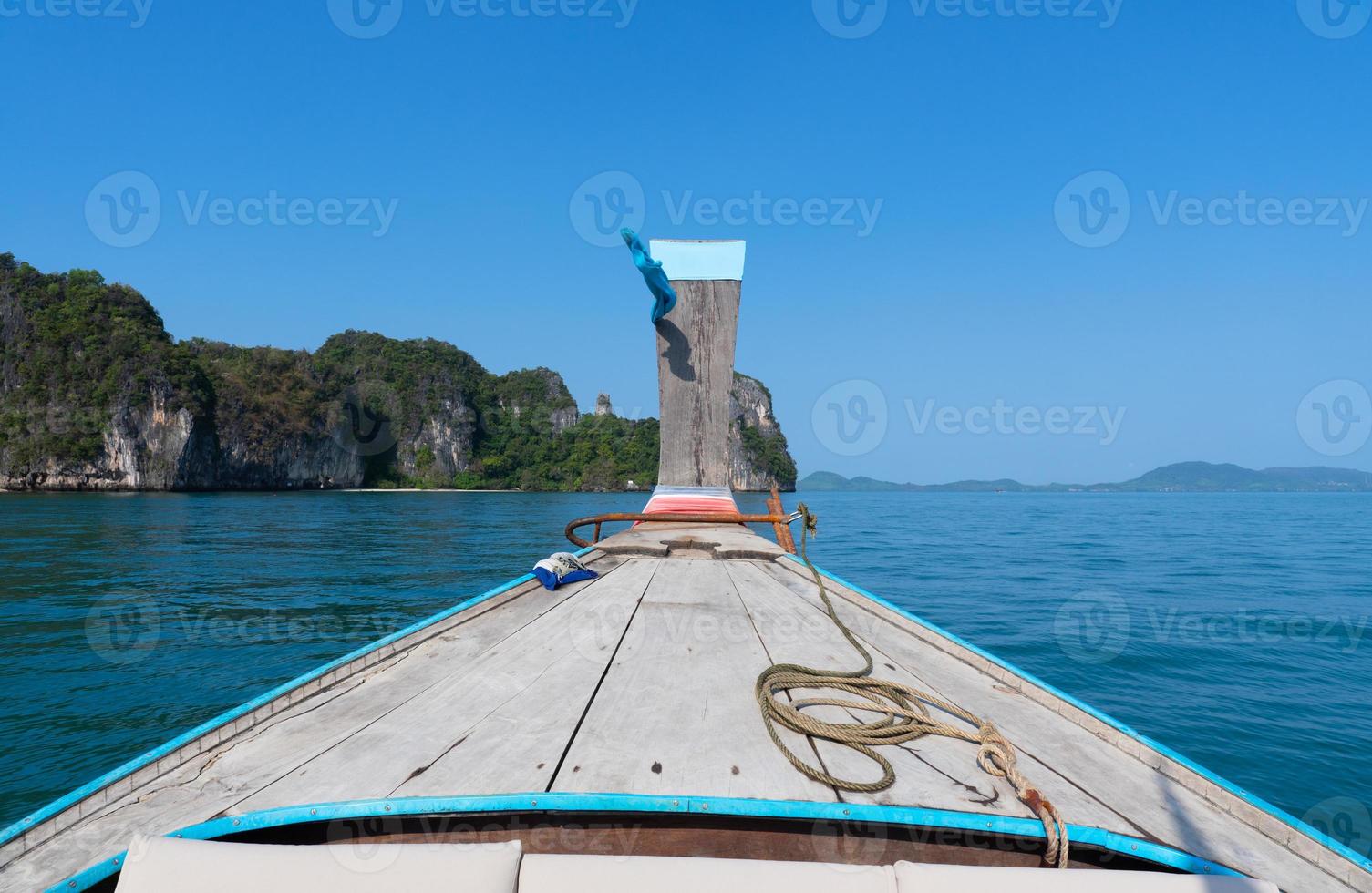 the bow of long tail boat riding on blue sea in sunny day of summer season photo