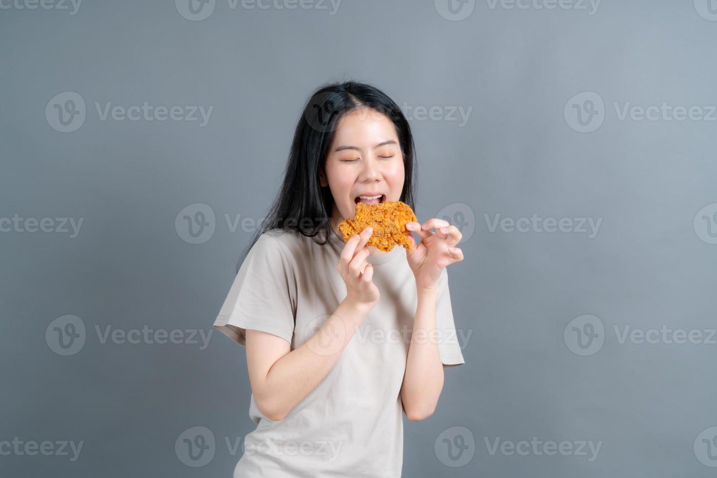 Young asian woman with happy face and enjoy eating fried chicken photo